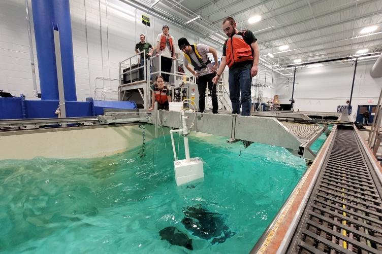 UNH students test a device in a wave tank