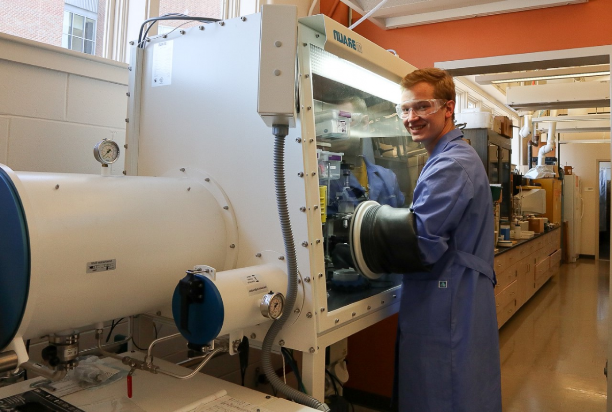 UNH PhD candidate Nick Pollack in front of large research machine