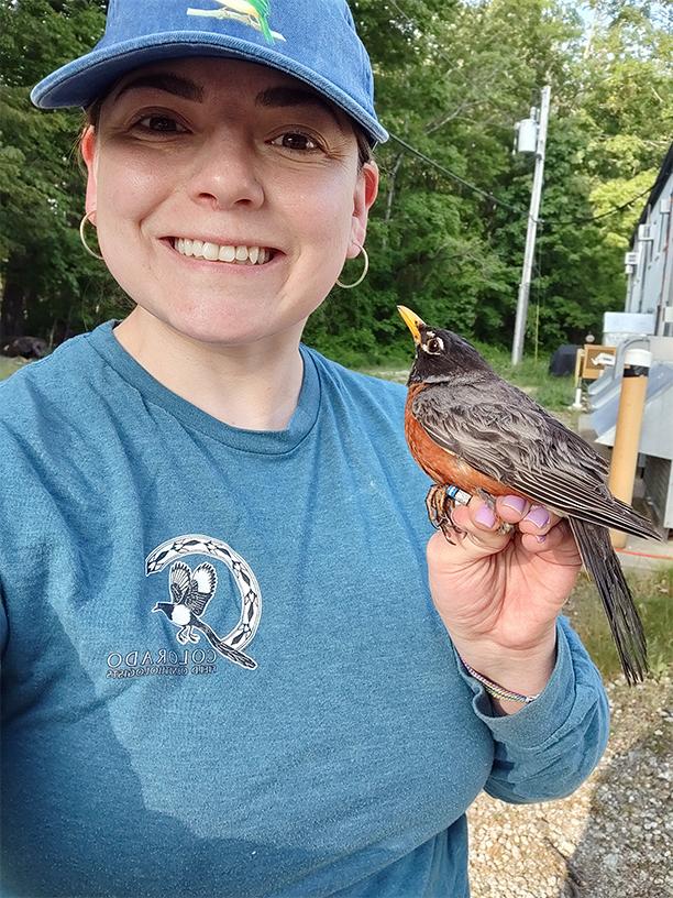 Urban ecology specialist Karina Sanchez holds an American robin on her hand.